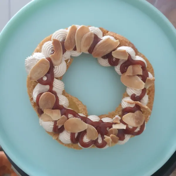 Semprotkan Saus Caramel, Taburkan dengan almond Flakes di atasnya dan semprotkan kembali dengan Cream Caramel,tutup dan taburkan gula bubuk dan almond Flakes di atasnya. Sajikan.