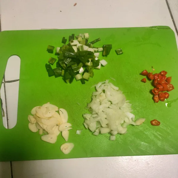 Cincang bawang bombay. Rajang bawang putih. Potong-potong cabai, bawang prei, dan daun bawang.