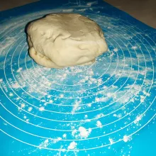 Pastikan alas ditaburi tepung agar adonan tidak lengket saat digilas. Lalu gilas dengan rolling pin hingga lebih besar daripada ukuran korsvetnya.