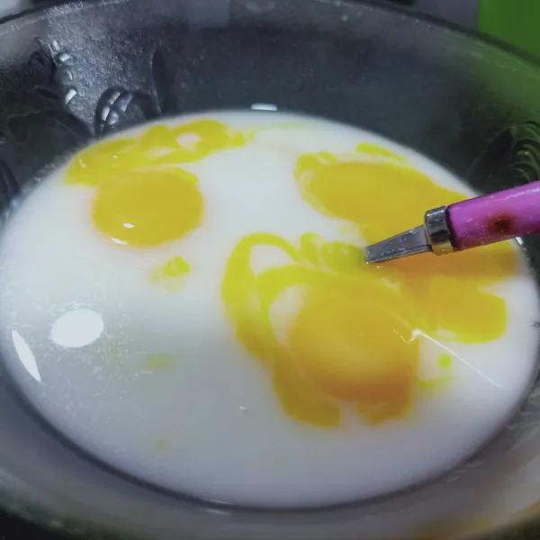 Tambahkan susu kental manis, kuning telur dan fanily, aduk sampai tercampur rata.