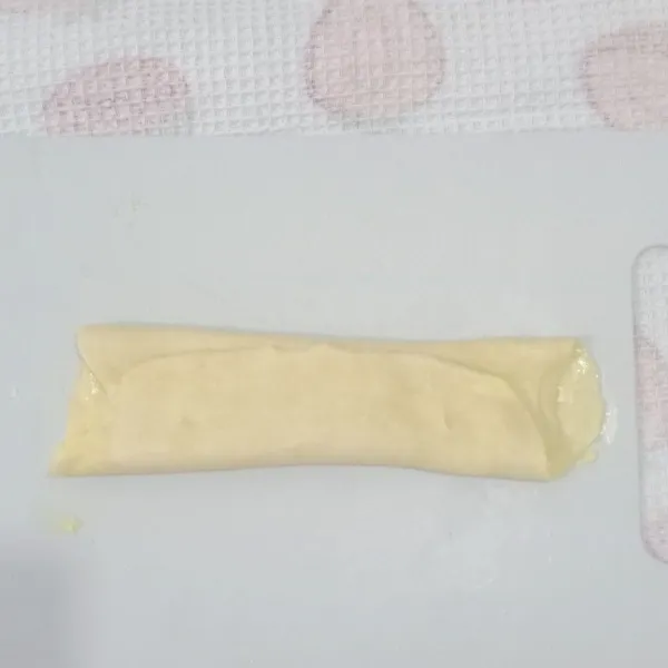 Pipihkan adonan dan olesi dengan 10 g mentega (suhu ruang) lalu lipat seperti pada gambar (Bagi menjadi 3 bagian dan lipat ke tengah).