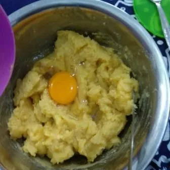 Tambahkan telur satu persatu, aduk dengan spatula setelah telur pertama tercampur rata baru masukkan yang berikutnya sampai adonan mengkilat.
