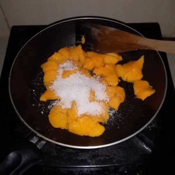 Cuci buah mangga lalu kupas dan potong sesuai selera. Campurkan buah mangga dan gula pasir.