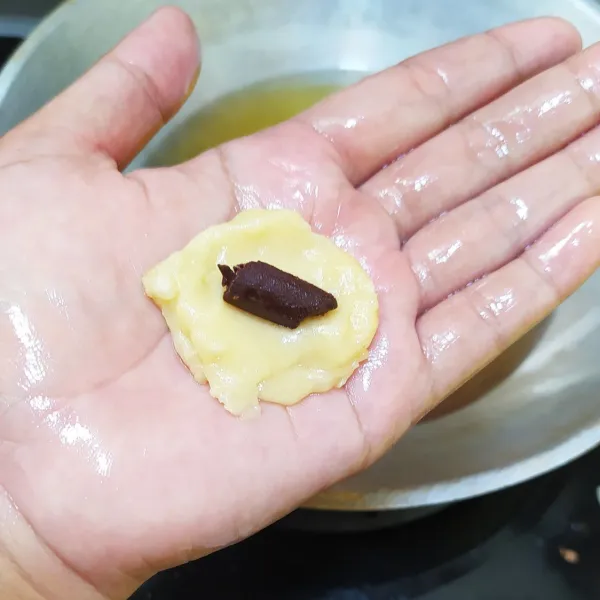 ambil secukupnya adonan lalu isi coklat bulatkan tekan sedikit agar pipih, gunakan minyak pada tangan agar tidak lengket.