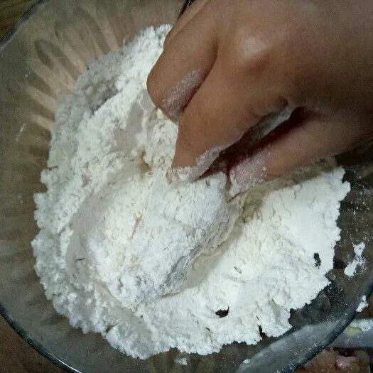 Remas-remas ayam dengan tepung hingga keriting tepung terbentuk.