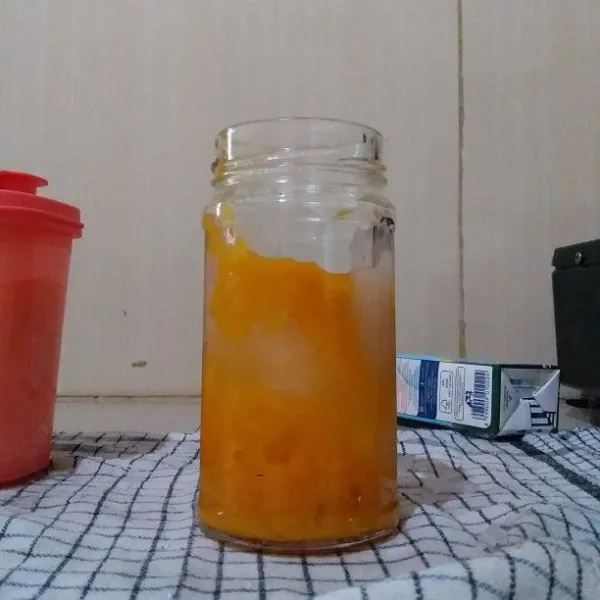 Siapkan gelas saji. Masukan buah mangga yang telah dimasak. Tambahkan es batu secukupnya.