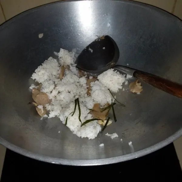 Masukkan nasi dan daun jeruk. Aduk hingga nasi tidak menggumpal.