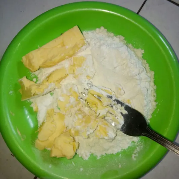 Siapkan wadah,masukan tepung terigu dan margarin beku.Hancurkan margarin dengan garpu sampai tercampur rata dengan tepung
