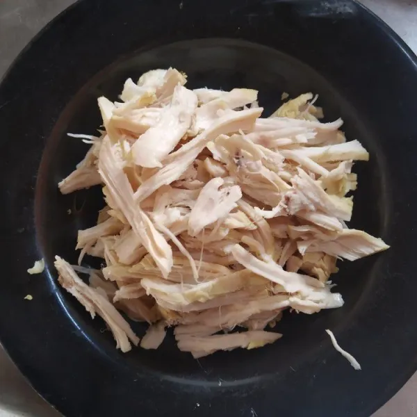 Ambil ayam dari rebusan kuah, kemudian suwir-suwir