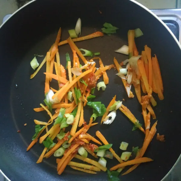 Tambahkan wortel dan daun bawang, masak hingga sayuran layu.