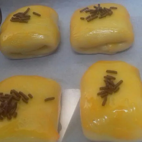 tata di loyang. panaskan oven. oles bolen dengan bahan olesan, beri sedikit misis coklat. panggang dengan suhu 180 dercel, selama kurang lebih 25 menit hingga kecoklatan.