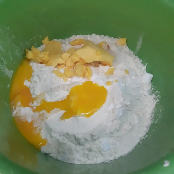Masukan tepung ke dalam wadah. Tambahkan margarin, gula halus, garam halus, air, dan kuning telur. Aduk hingga rata