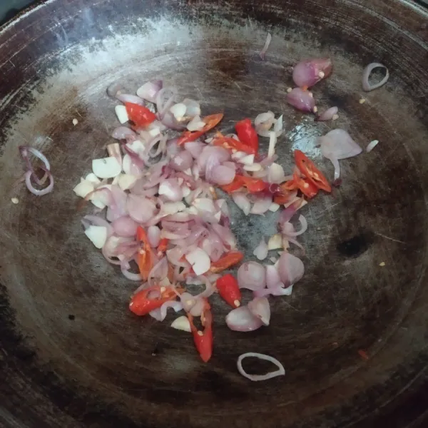 Tumis bawang merah dan bawang putih sampai harum, masukkan irisan cabai rawit lalu aduk sebentar.