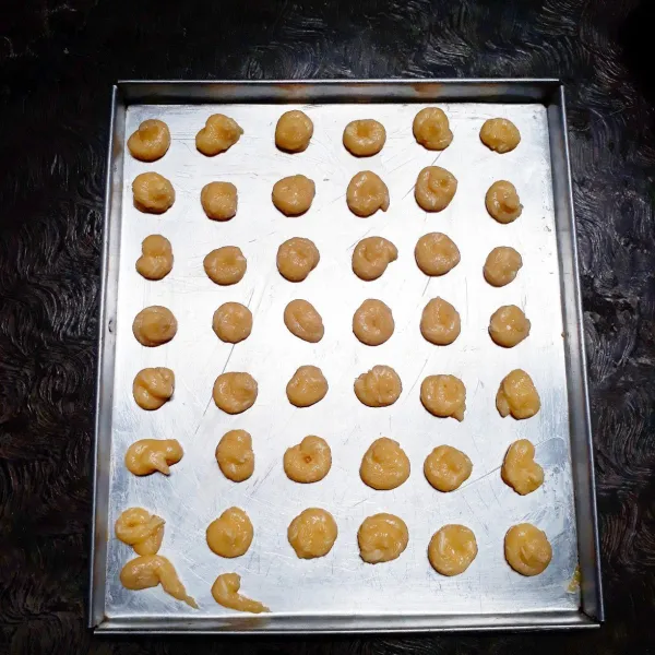 Tuang kedalam piping bag dan spluit bentuk kedalam loyamg bersemir margarin.