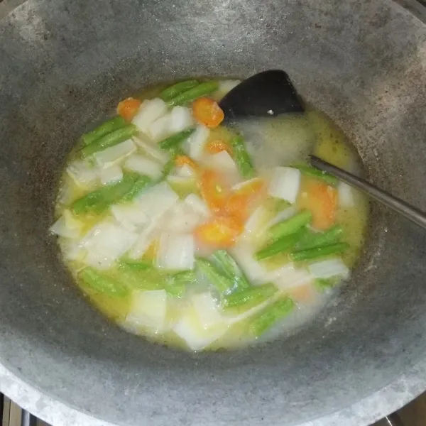 Masukan wortel, buncis, dan bongkol sawi (bagian yang keras). Aduk rata sayuran dengan bumbu lalu masukan sedikit air dan tutup wajan agar sayuran lebih cepat empuk.