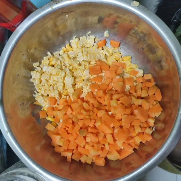 Kupas dan cuci bersih wortel beserta jagung. Potong dadu kecil-kecil wortel. Iris buah jagung.