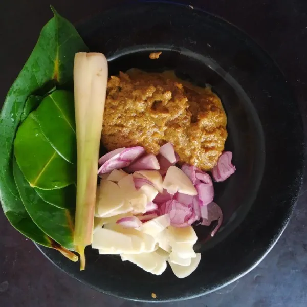 Haluskan bawang putih, bawang merah, kunyit, dan jahe (sisihkan 1-2 siung untuk dirajang). Kemudian cuci bersih daun salam, daun jeruk, dan serai