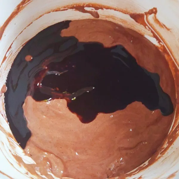 Bila sudah tercampur rata masukan coklat dan mentega yang sudah di tim secara bertahap sambil diaduk menggunakan spatula. Panaskan oven pada suhu 180°C