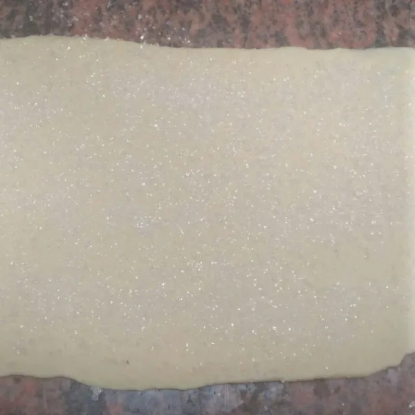 Taburi dengan gula pasir sampai rata sambil di tepuk tepuk agar gula menempel.