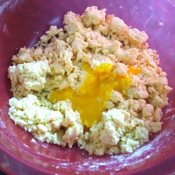 Membuat crust : campur tepung dan margarin menggunakan tangan, lalu tambahkan kuning telur, campurkan hingga adonan kalis dan dapat dibentuk.