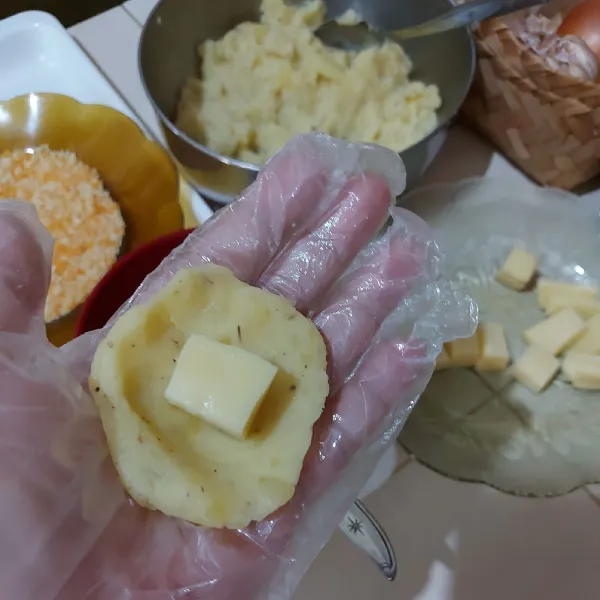 Ambil secukupnya adonan, pipihkan lalu isi dengan potongan mozzarella. Tutup rata dan bulatkan. Lakukan sampai selesai.
