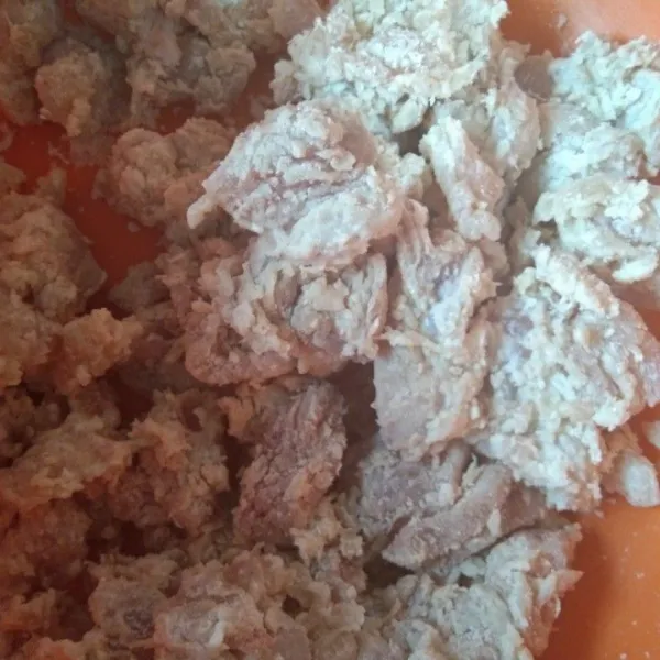 Masukkan potongan daging ayam ke dalam tepung, cubit cubit agar tepung menempel pada daging ayam.