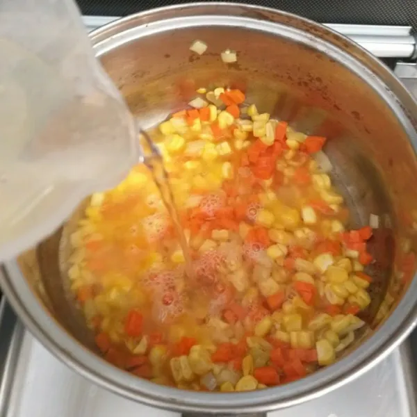 Masukkan wortel dan jagung, aduk rata. Masukkan air, masak sampai sayuran empuk.
