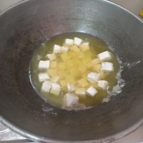 Panaskan minyak lalu masukkan tahu. Goreng hingga kuning keemasan.