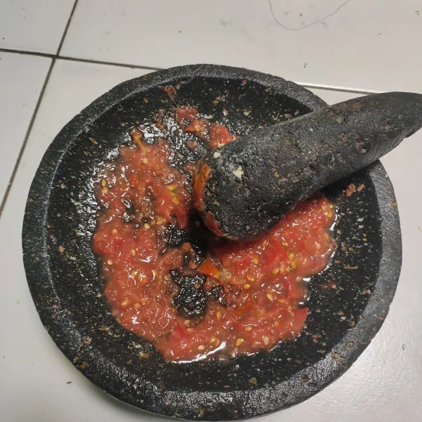 Untuk sambal, ulek halus garam, terasi, dan cabai rawit. Setelah itu potong dadu atau parut tomat. Ulek halus kembali dan tes rasa. Sajikan bersama ikan goreng.