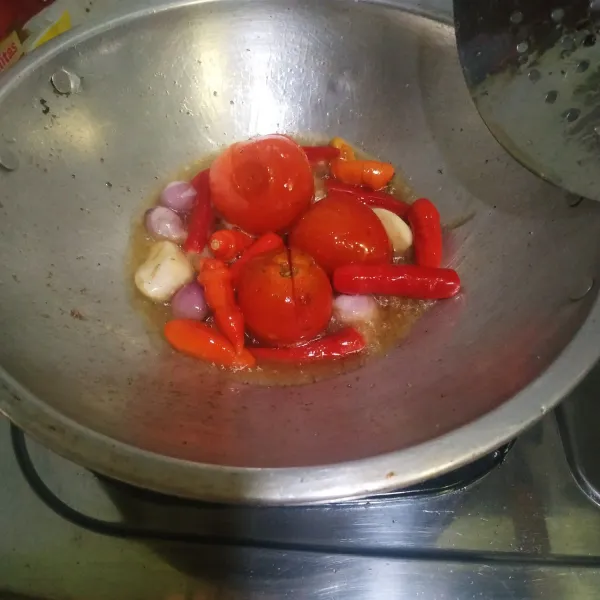 Goreng tomat, cabai merah, cabai rawit, bawang merah, bawang putih, dan terasi hingga tomat layu.