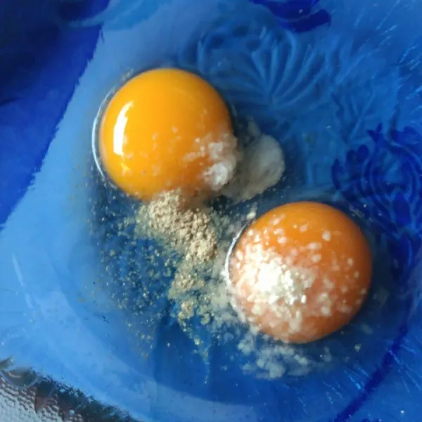 Dalam wadah kocok lepas telur berserta garam, merica bubuk dan kaldu jamur.