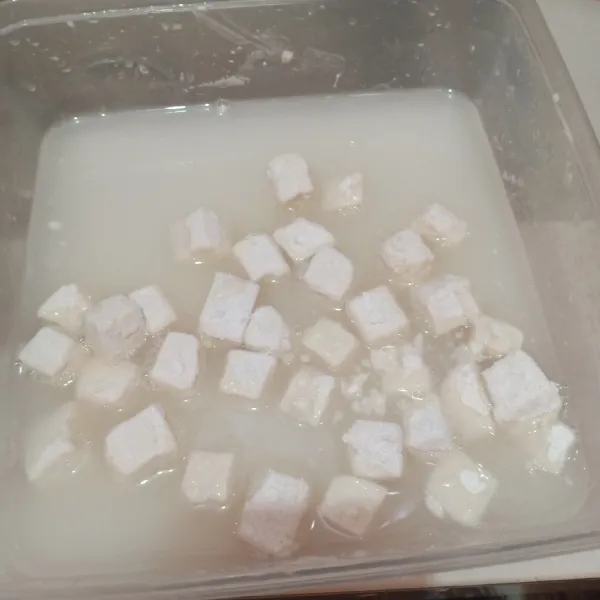 Masukan tahu yang sudah bertepung ke dalam air garam. Lalu masukkan kembali ke dalam tepung kering sehingga menghasilkan lapisan tepung yang cukup tebal.