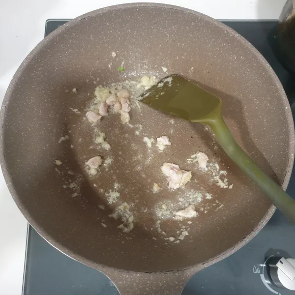 Panaskan minyak sayur tumiskan bawang putih dan ayam, sampai harum dan ayam matang.