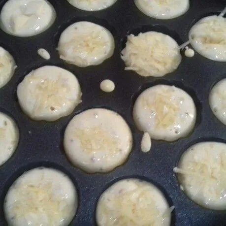 panaskan snack maker. tuang adonan 1/2 bagian lubang cetakan. beri isian keju atau chocochip. balik kue agar matang merata dan bisa berbentuk bulat.