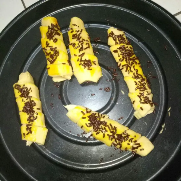 Siapkan loyang dan olesi margarin.Tata molen pisang dan olesi permukaan molen dengan kuning telur lalu taburi mesis.Oven selama 20 menit dengan suhu 210°C.Angkat dan sajikan jika sudah dingin.