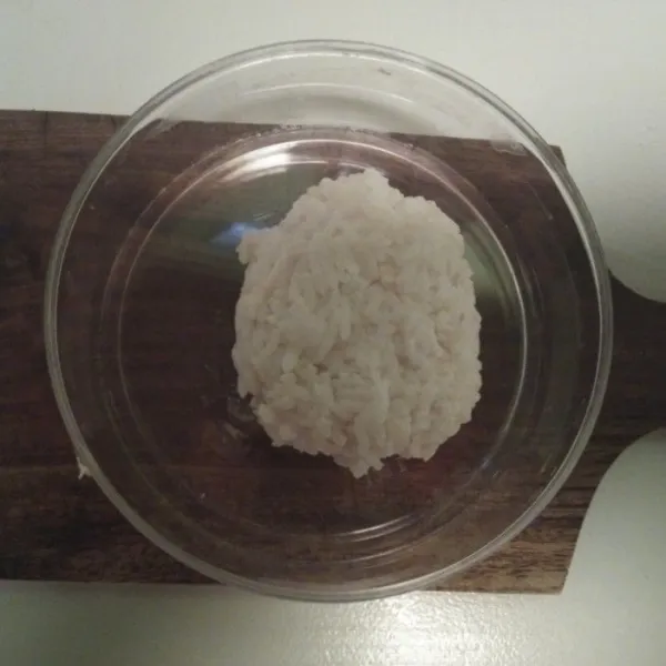 Bentuk oval nasi dan taruh di box makanan.