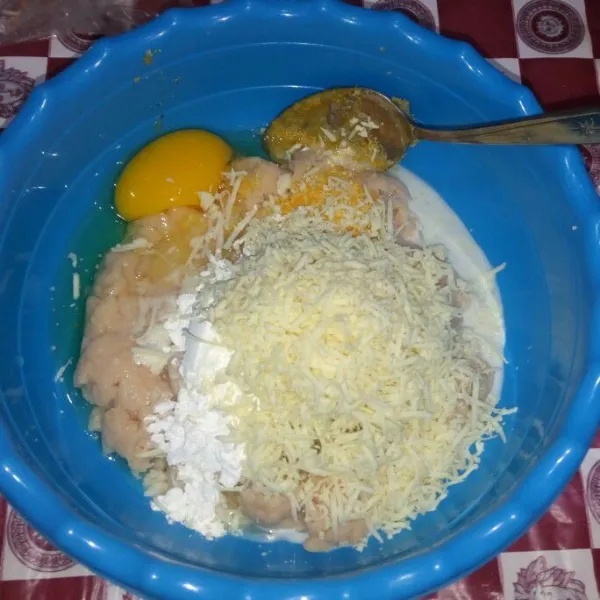 Di wadah campur ayam halus dengan keju parut, telur, tepung roti, tapioka, bumbu halus, susu, garam dan kaldu jamur.