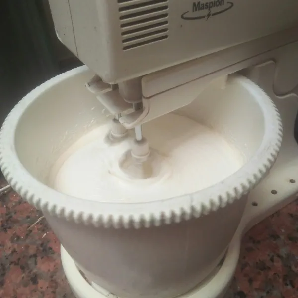 Masukan susu cair lalu mixer dengan kecepatan tinggi sampai adonan mengembang putih kental berjejak,  sekitar 10 menitan.