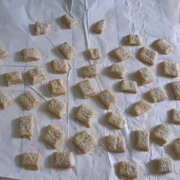 Kemudian potong-potong lalu oleskan dengan air dan taburi dengan biji wijen, diamkan selama 10 -15 menit.