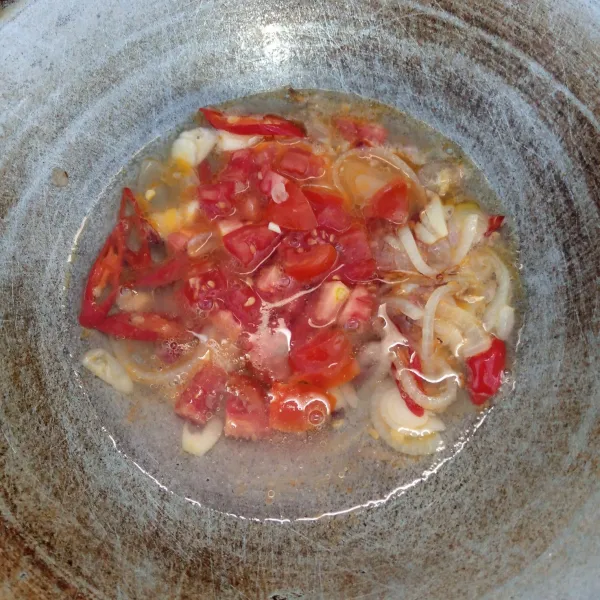 Masukkan tomat dan air. Masak sampai mendidih dan tomat layu.