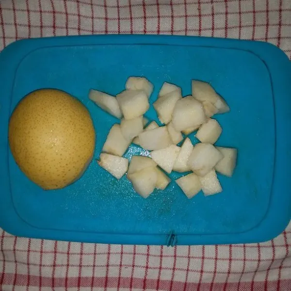 Cuci buah pir. Kupas dan potong dadu. Kemudian rendam di air garam.