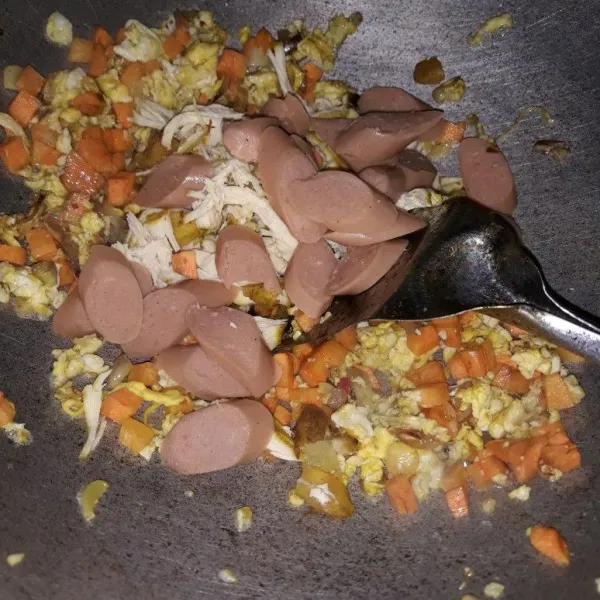 Selanjutnya masukan wortel masak sebentar. lalu masukan telur aduk-aduk,tambakan sosis dan ayam suir, garam,gula pasir dan kaldu bubuk. aduk sampai rata.