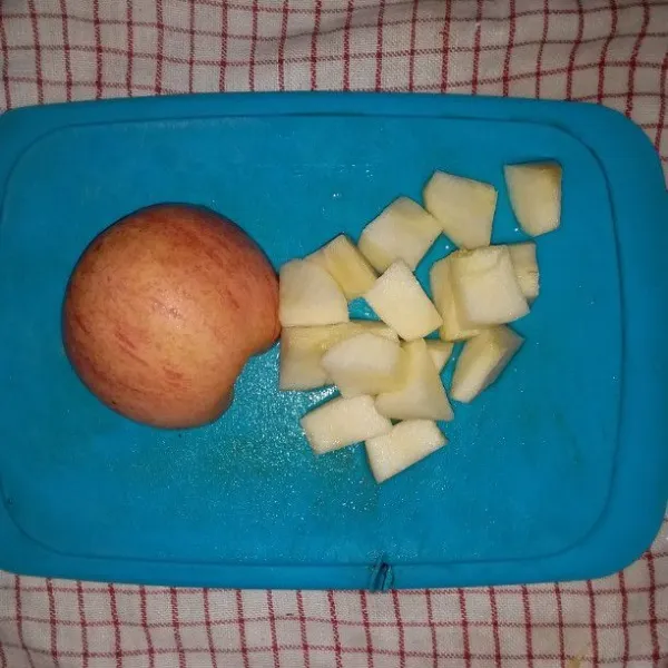 Cuci buah apel. Kupas dan potong dadu. Kemudian rendam di air garam.