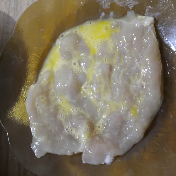 Setelah 30 menit, keluarkan ayam dari chiller, lalu celupkan ayam kedalam kocokan telur.