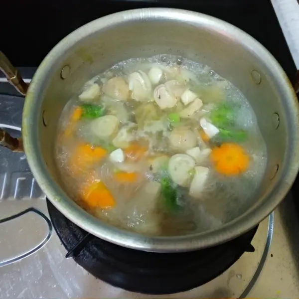 Masukkan tomat, daun bawang, seledri, garam, merica bubuk, kalsu jamur. Koreksi rasa