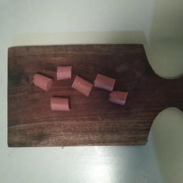 Potong sosis menjadi empat bagian. Potong sosis pada bagian tengahnya seperti kaki gurita.