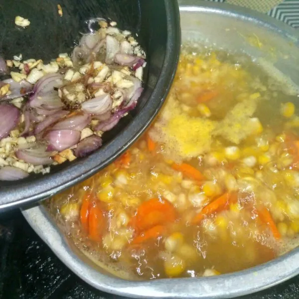 Rebus air, jagung, dan wortel, masukkan bumbu yang sudah ditumis.