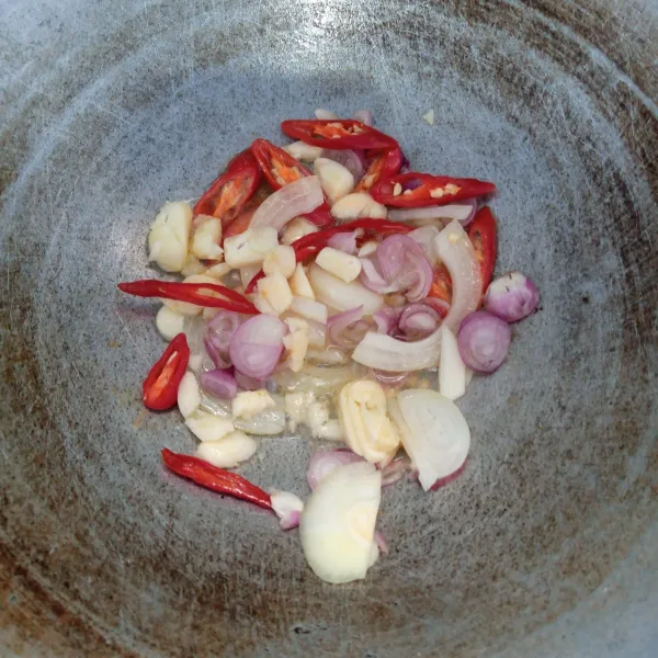 Tumis bawang merah, bawang putih, bawang bombai, dan cabai merah sampai harum dan layu.