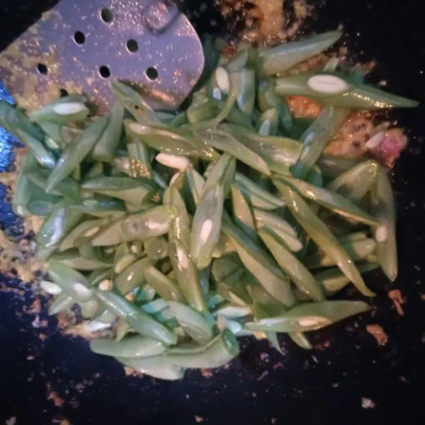 Masukkan buncis yang sudah dipotong serong. Aduk rata. Beri air kurang lebih sampai buncis terendam.