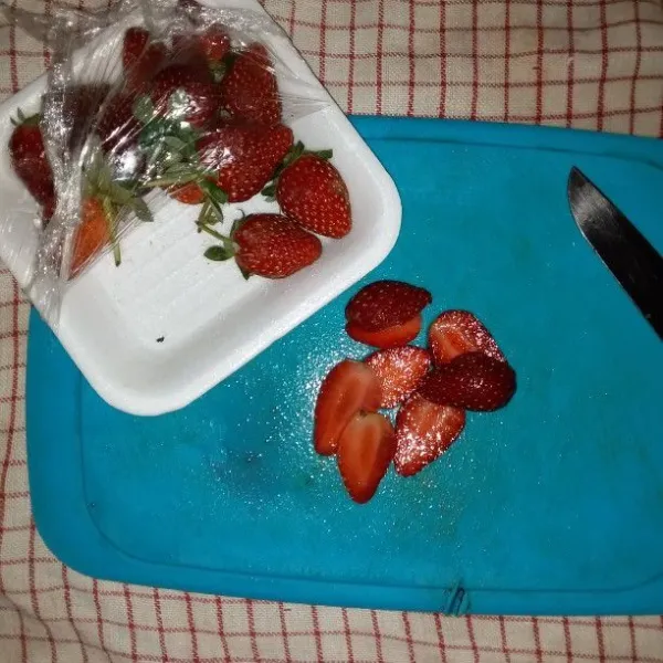 Buang tangkai buah strawbery. Cuci dan potong sesuai selera.